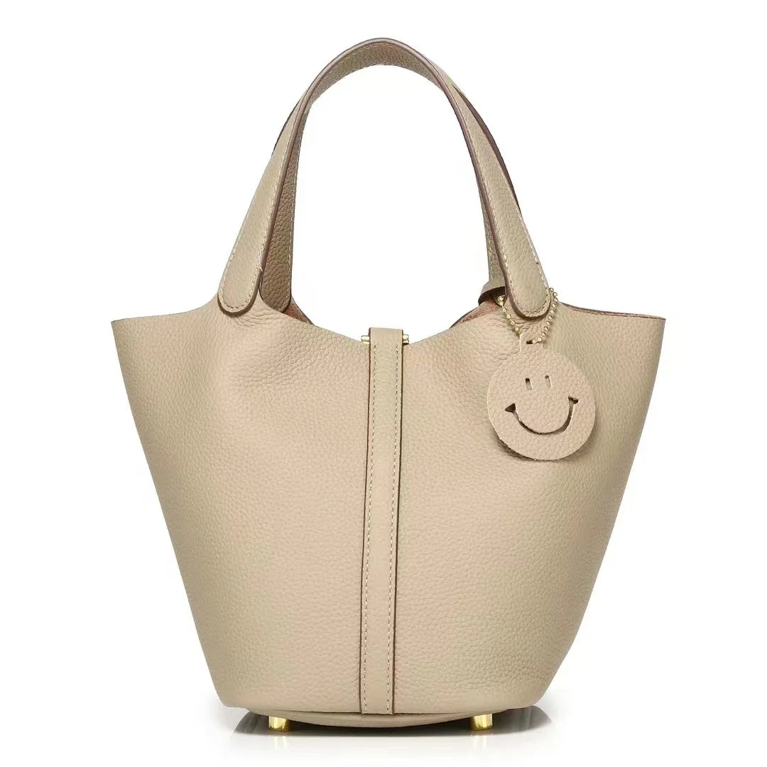New Leather Luxury Handbag, High-end in beige with a smiley decoration and dual handles.