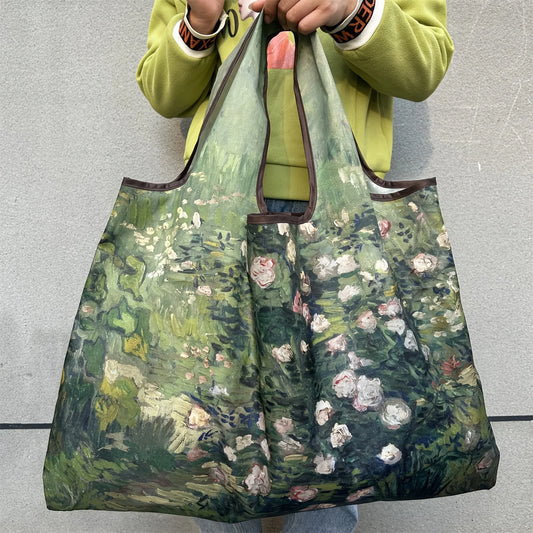Large Foldable Shopping Bag New Fashion with floral design held by a person against a grey background.