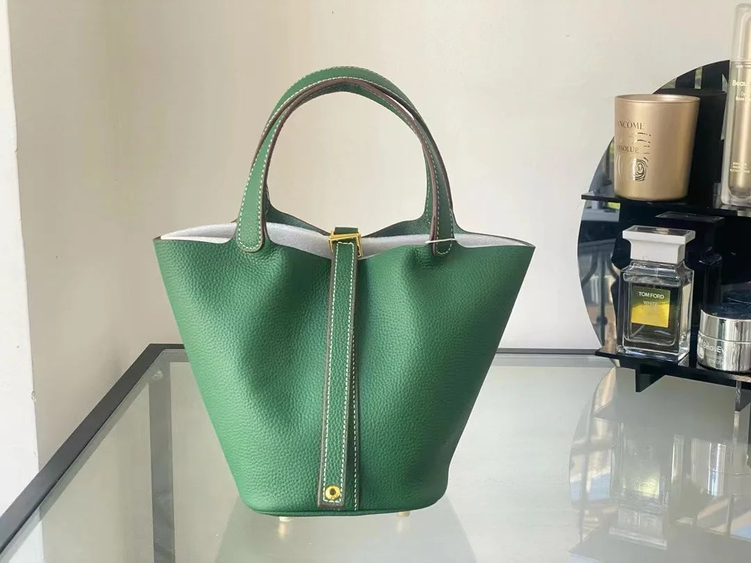 New Leather Luxury Handbag, High-end in green color displayed on a glass surface.