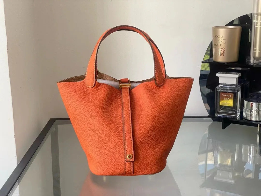 New Leather Luxury Handbag, High-end in vibrant orange color, bucket shaped design, perfect for leisure travel.